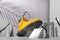 Shoe concept, yellow boots on the stairs, women`s legs and hands, palm shade on gray background, arch and other geometric shapes