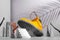 Shoe concept, yellow boots on the stairs, women`s legs and hands, palm shade on gray background, arch and other geometric shapes