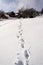 Shoe footprint in fresh snow on empty ski slope, winter snowy landscape on sunny day, white copy space, new year resolution