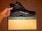 Shoe leather black new, for walking in winter, standing on beige paper box
