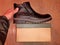 Shoe leather black new for walking in winter, standing on brown paper box