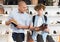 Shoe salesman helping teen to choose fashionable winter boots at shoe shop