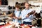 Shoe salesman helping teen to choose fashionable winter boots at shoe shop