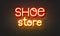 Shoe store neon sign on brick wall background.