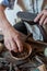 The shoemaker repairs a shoe at his work bench