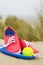 Shoes, ball and frisbee on beach