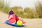 Shoes, ball and frisbee on beach landscape