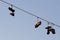 Shoes dangling on a electric cable over the street