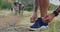 Shoes, hands and man in nature for running, workout or training with biking friends. Sneakers, shoelace and male runner