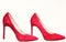 Shoes made out of red suede on white background, isolated. Pair of fashionable high heeled pump shoes. Footwear for