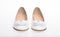 Shoes made out of white leather on white background, isolated. Footwear for women on flat sole with pearl bead as decor