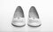 Shoes made out of white leather on white background, isolated. Footwear for women on flat sole with pearl bead as decor