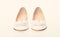 Shoes made out of white leather on white background, isolated. Footwear for women on flat sole with pearl bead as decor