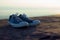 Shoes on rocks with cliffs, blue sky and sea as a background Represents the conceptual