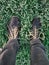 Shoes among-st green grass blades with early morning frost