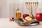 Shofar and Rosh Hashanah holiday attributes on white wooden table indoors