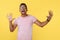 Shoked successful african american young man with hands wide open over yellow background.