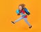 Shool kid jump with school bag and globe. Full length body of little school kid jumping having fun isolated yellow color