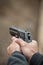 Shooter holding gun in hand and shooting. Close-up detail view