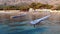 Shooting from drone of a young girl stands on a plastic modular pontoon among the waves of the sea. Contemplation and