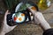 Shooting food on phone`s camera, Fried eggs in an old pan with tomatoes on a wooden table, Selective focus, Food Photographer, Clo