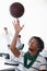 Shooting hoops after work. A young man playing with a basketball while sitting in the office.