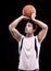 Shooting hoops. A young man about to throw a basketball against a black background.