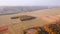 Shooting from a quadcopter flying over the golden field and agricultural lands. Filmed in 4k, drone video