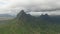 Shooting from top to bottom the peaks of mountains and jungles of Mauritius, the sky in clouds