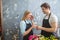 Shop assistant giving flower to his embarrased collegue