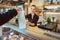 Shop assistant handing over bag with groceries to customer