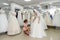 Shop assistant helps bride with wedding dress in boutique