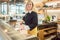 Shop clerk in deli cutting cheese