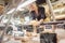 Shop clerk woman sorting cheese in the supermarket display