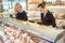 Shop clerk women at the cheese counter in a supermarket