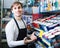 Shop employee posing near stand with wall paint