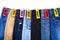 Shop sale of clothes, jeans of different colors blue, green, black on white background isolated close up