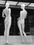 Shop showcase in the off-season-two nude mannequins on a black background.