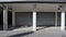 Shop with shutters lowered, under a porch with columns. White wall, shadows and in front a tiled pavement.