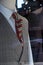 Shop window of mens tailor shop showing a mannequin in a black grey and white check suit with maroon tie