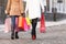 Shopaholics at work. Rear view of two women walking with shopping bags in their hands