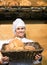 Shopgirl working in bakery with bread and different pastry