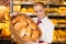 Shopkeeper in baker\'s shop presenting buns in a basket