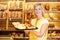 Shopkeeper in baker shop with tablet full of cake