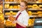 Shopkeeper in Bakery giving bread to customer