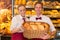 Shopkeepers in baker\'s shop presenting buns in a basket