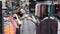 Shopper, charming smiling young woman loving shopping trying on beautiful jacket in fashion store