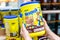 Shopper`s hand holding a plastic container of NestlÃ© Brand Nesquik chocolate powdered flavoring mix