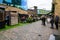 Shoppers and diners on a cobbled street at Camden Market with the famous Camden Lock painted sign on the bridge over Camden High