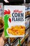 Shoppers hand holding a package Kellogg`s Brand Original Corn Flakes cereal